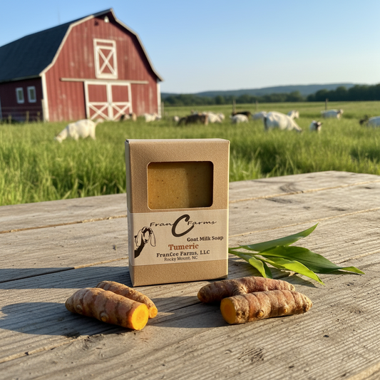 Turmeric Goat Milk Soap displayed with fresh turmeric roots in front of a barn and cows in a grassy field.