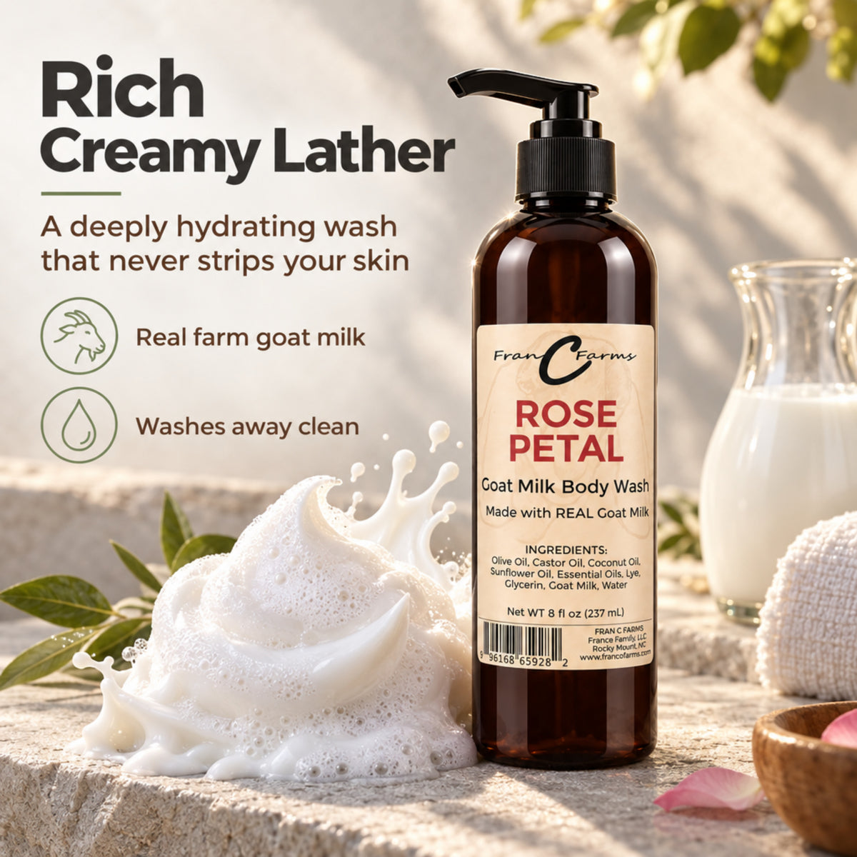 Rose Petal Goat Milk Body Wash with creamy lather and a pitcher of goat milk on a stone bathroom counter