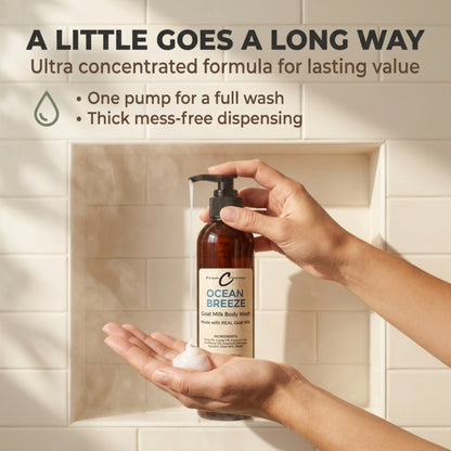 Hands pumping Ocean Breeze goat milk body wash into a palm in front of a tiled shower niche.