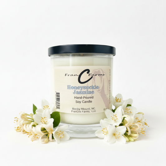 Honeysuckle Jasmine Soy Candle in a jar surrounded by flowers, showcasing a floral fragrance.
