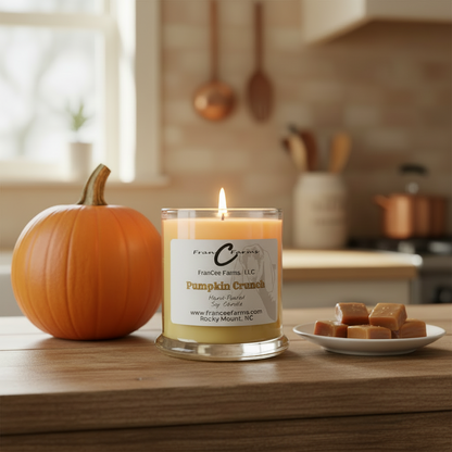 Pumpkin Crunch Soy Candle - 12 oz. Status Jar with glowing wick, pumpkin, and caramel squares in a kitchen setting.