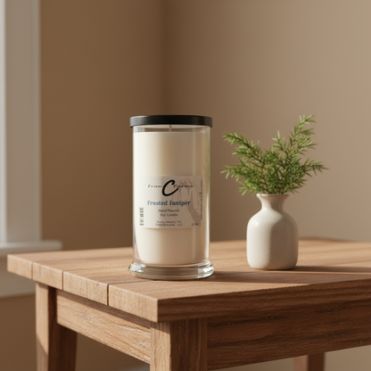 Frosted Juniper Soy Candle - 22 oz. Status Jar on a wooden table with a small vase and plant.