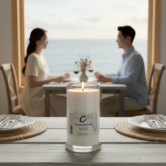 Ocean Breeze Soy Candle lit on a dining table with a couple enjoying a meal by the ocean.