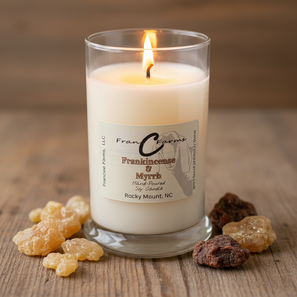 Frankinscense & Myrrh Soy Candle in a glass jar surrounded by resin pieces, lit and creating a warm ambiance.